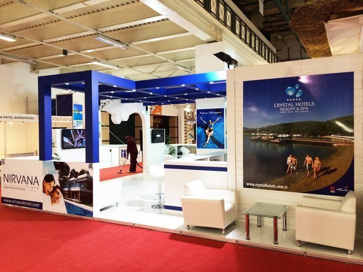Stand d’exposition bleu et blanc avec accueil et espace de rencontre